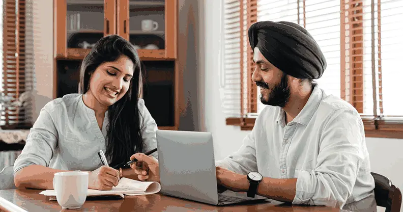 Two young professionals in India discussing a machine learning and AI courses career path over a laptop