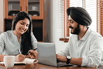 Two young professionals in India discussing a machine learning and AI courses career path over a laptop